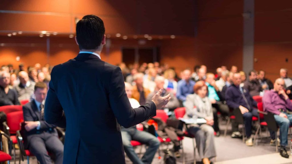 Photo of keynote speakers facing conference hal;